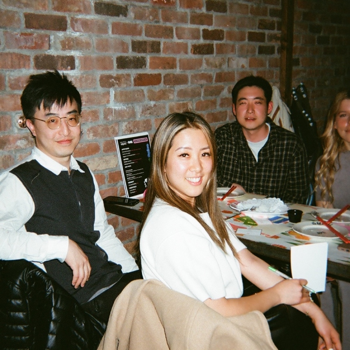 Guests gathered at a table with brick walls behind them