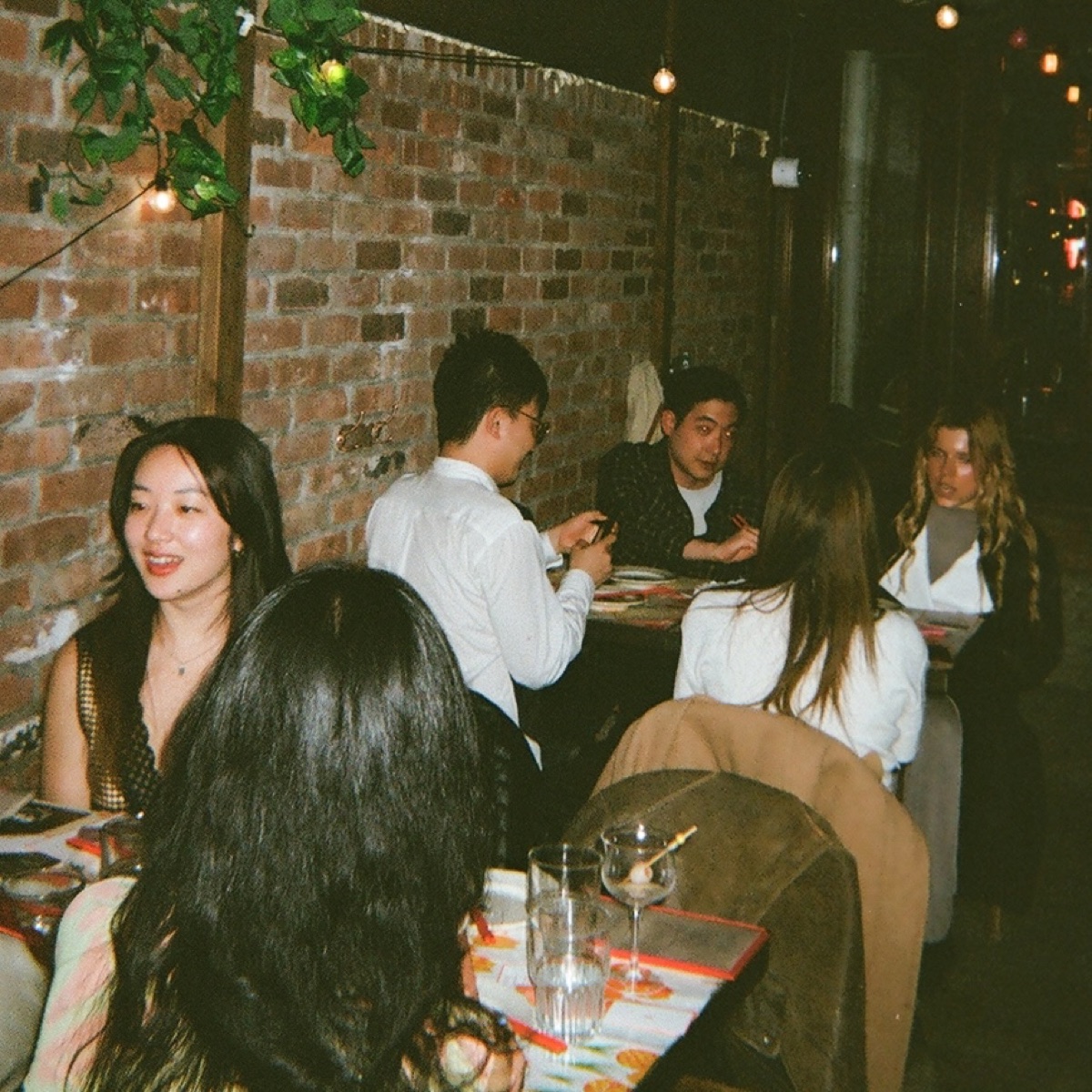 Guests dining and talking under red light